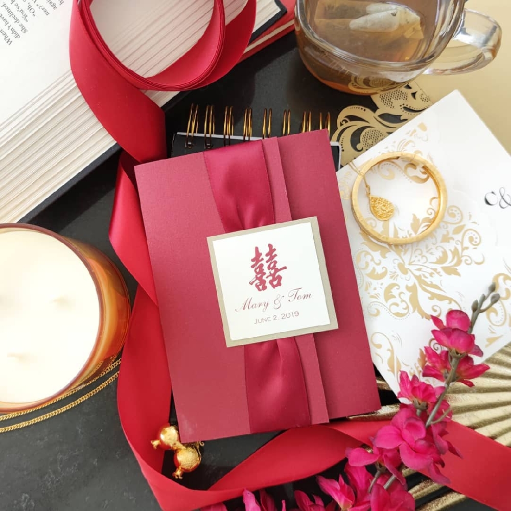 This is a Red and Gold Chinese wedding invitation with the Chinese symbol and the bride & groom\'s names on the cover.