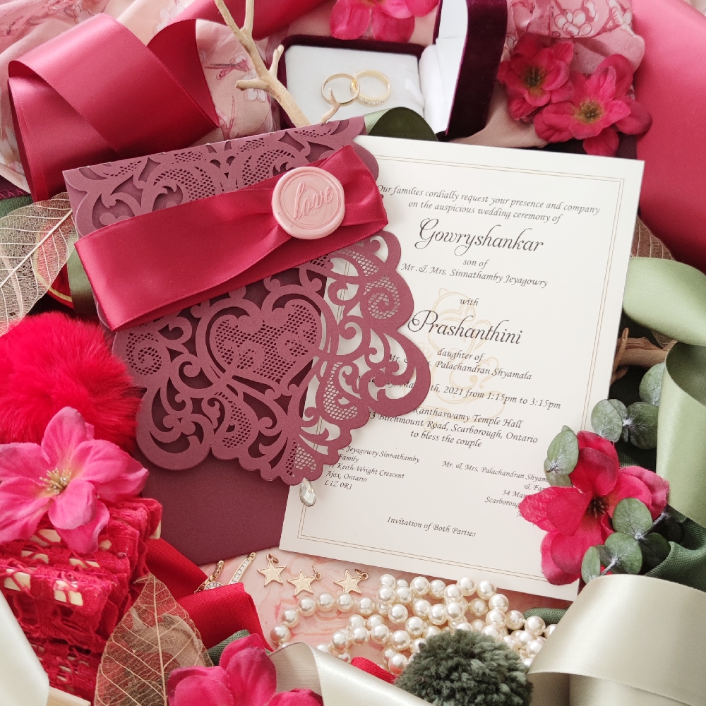 Burgundy fancy lace cut with invitation wording inside and sherry ribbon with pink love wax stamp on cover.