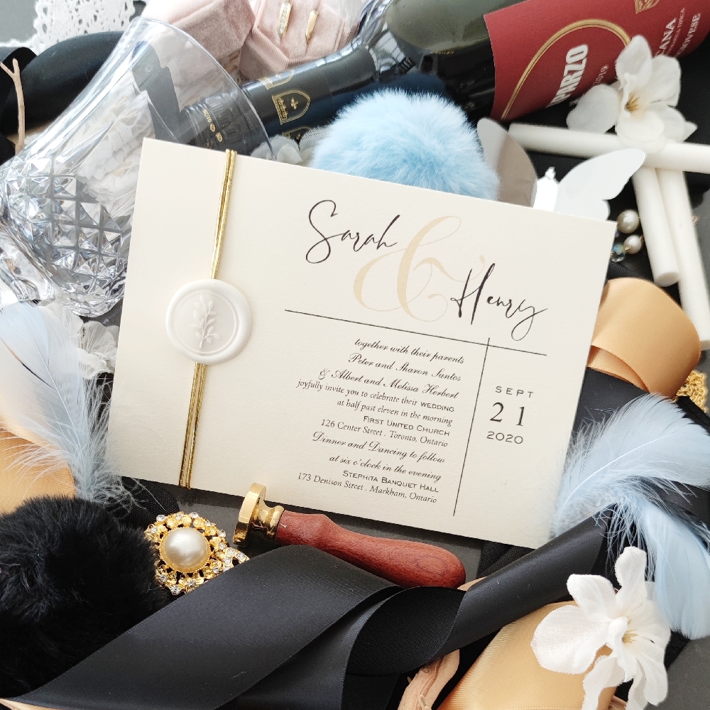 Landscape oriented wedding card printed on white gold pearl paper accented with gold string and ivory wax seal.