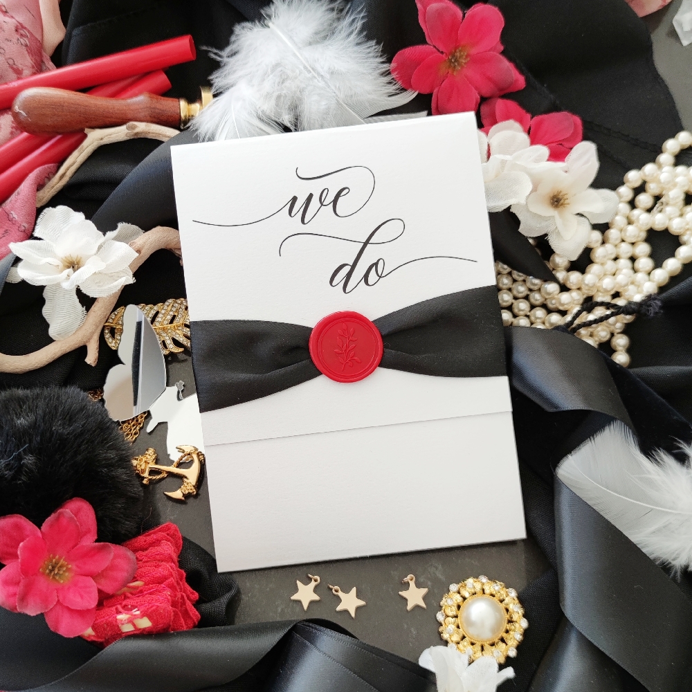 Black and white invite with a pop of red on the wax seal.