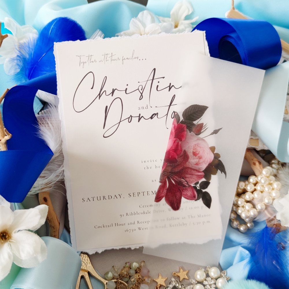 This invitation is printed on a deckled edge paper and it is wrapped in a burgundy floral vellum gate fold.