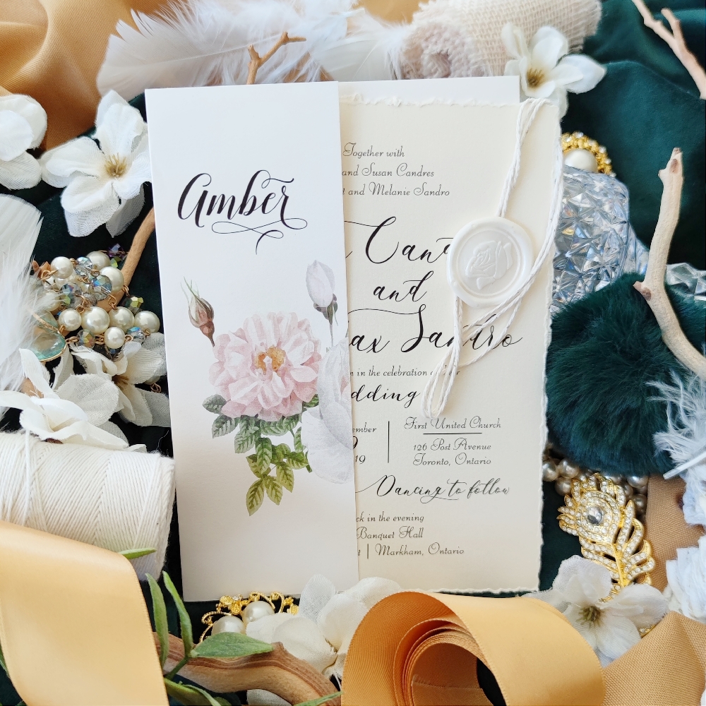 Deckled edge wedding invite paired with an ivory pearl paper gate fold with a white string and white rose seal.