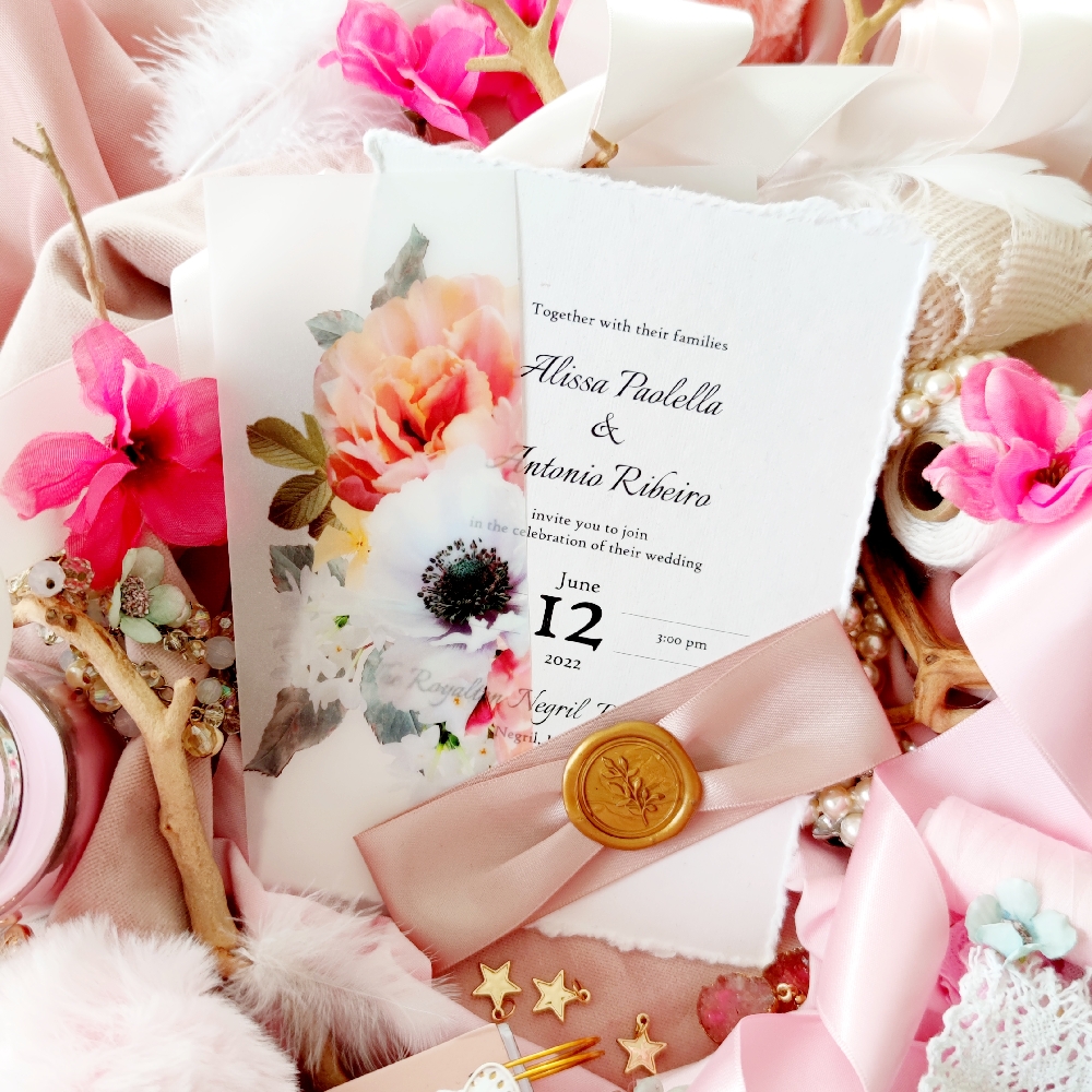 Deckle edge wedding invite with a printed full vellum wrap and ribbon and wax seal combo embellishment