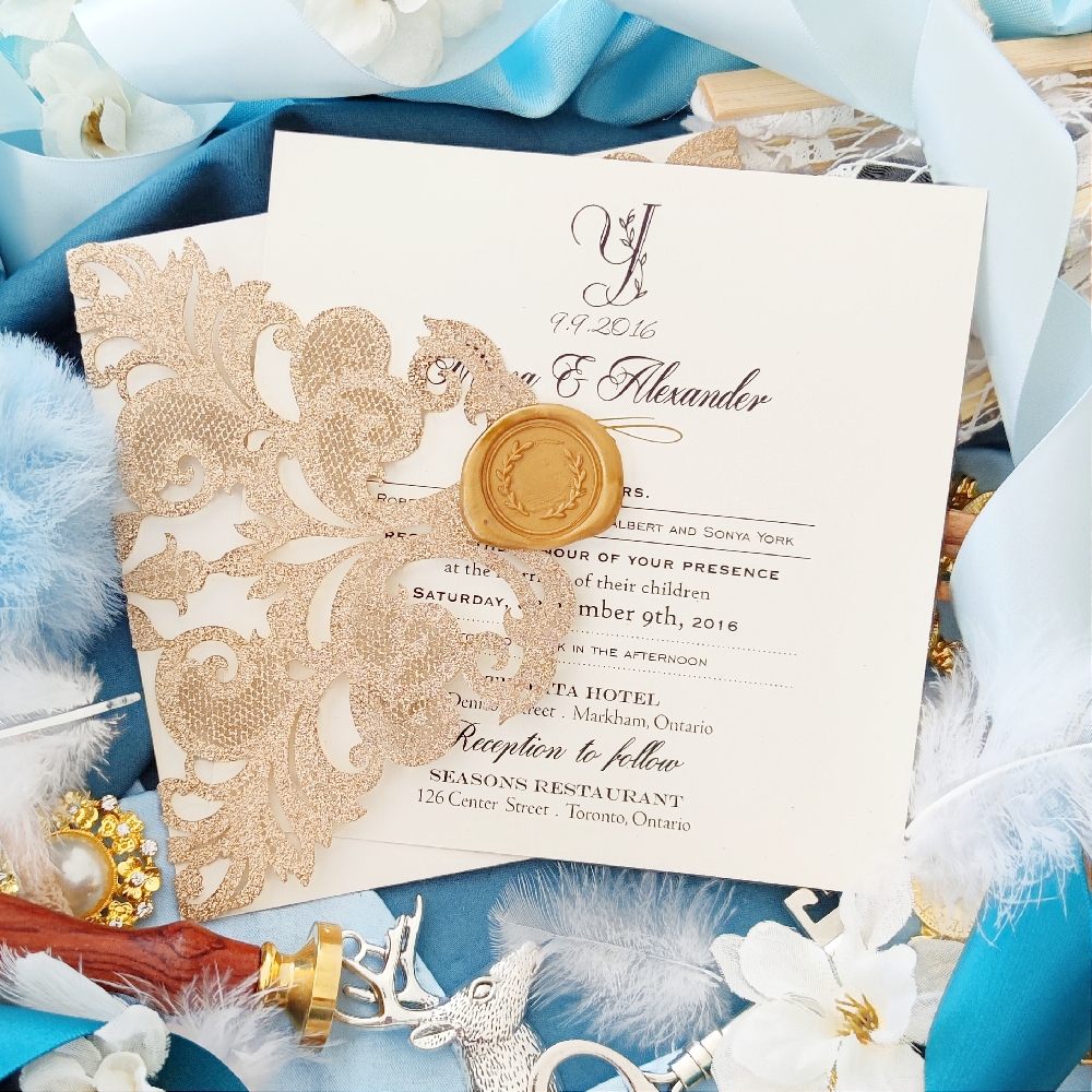 A champagne gold full glitter wedding invitation in a lasercut design.  The gold wax seal adds an additional element of elegance.