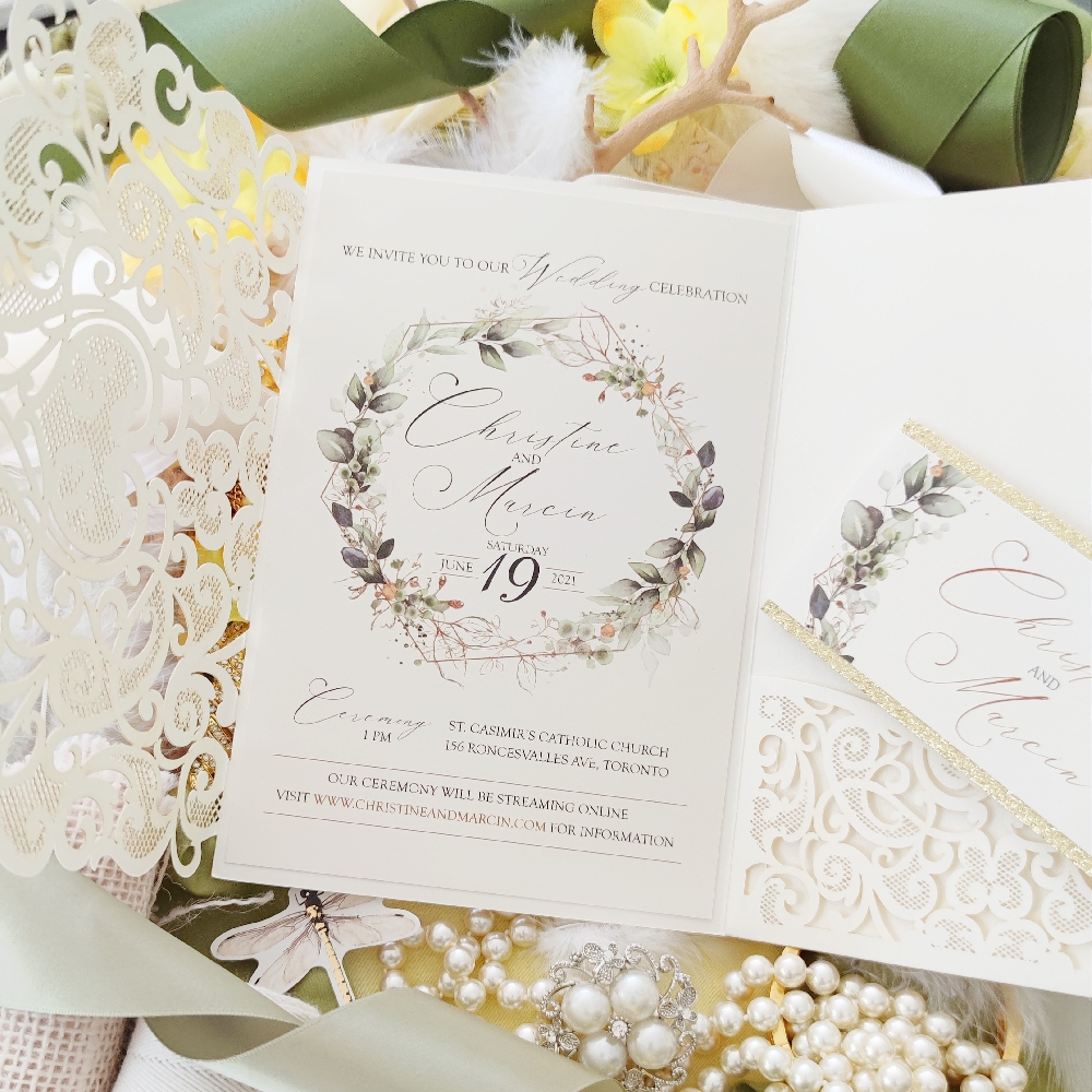 An ivory colored trifold lasercut wedding invitation.  The invitation wording is in the middle and a pocket is on the right.