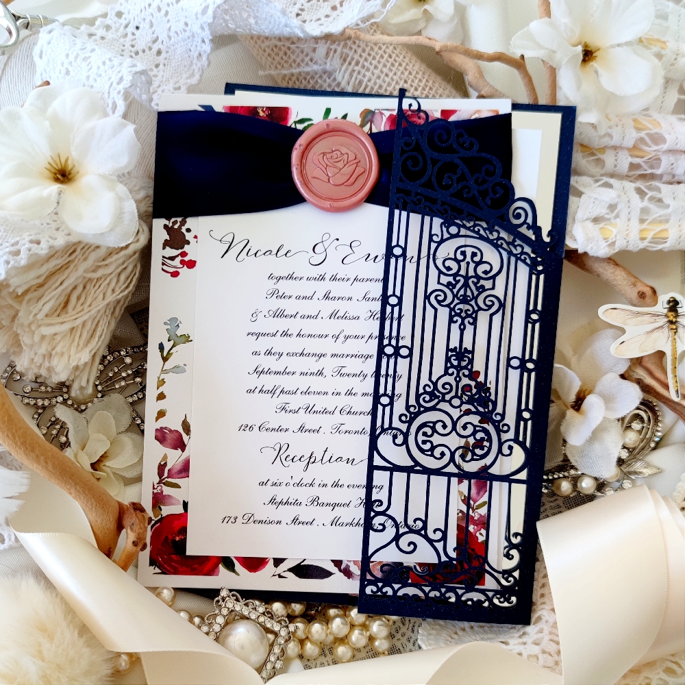 The navy ribbon with wax seal over the burgundy floral invitation is a design from our floral and wax seal collection.  The iron gate lasercut is a separate invitation design.