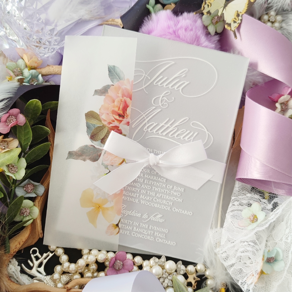 Julia & Matthew created an acrylic wedding invitation with a white bow tied around.