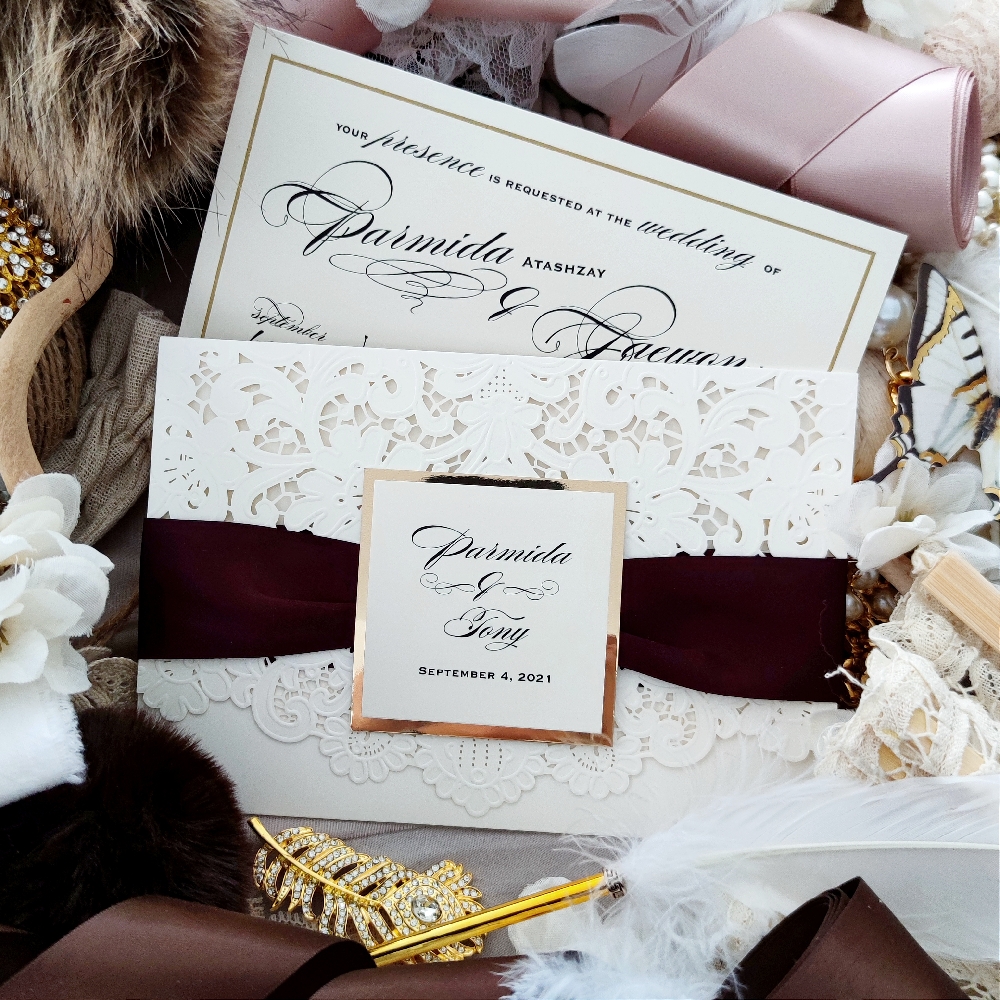 Parmida & Tony went with a class laser cut wedding invite in ivory shimmer.  They have an accent eggplant ribbon color around the cover flap with a gold mirror cover tag.  Their main layout insert has a nice gold line border.