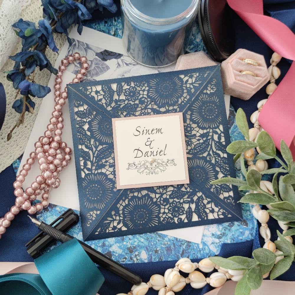 Glittering navy lasercut design with floral pattern and a blush cover tag.