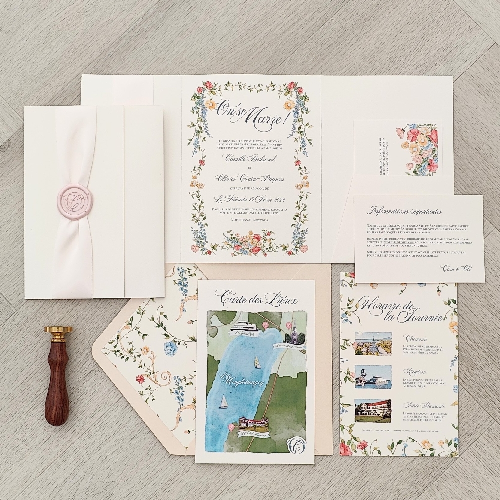 Pocketfold wedding invitation with a ribbon and wax seal embellishment.  Along with multiple inserts that go into a pocket and blush envelope with a design pattern liner.