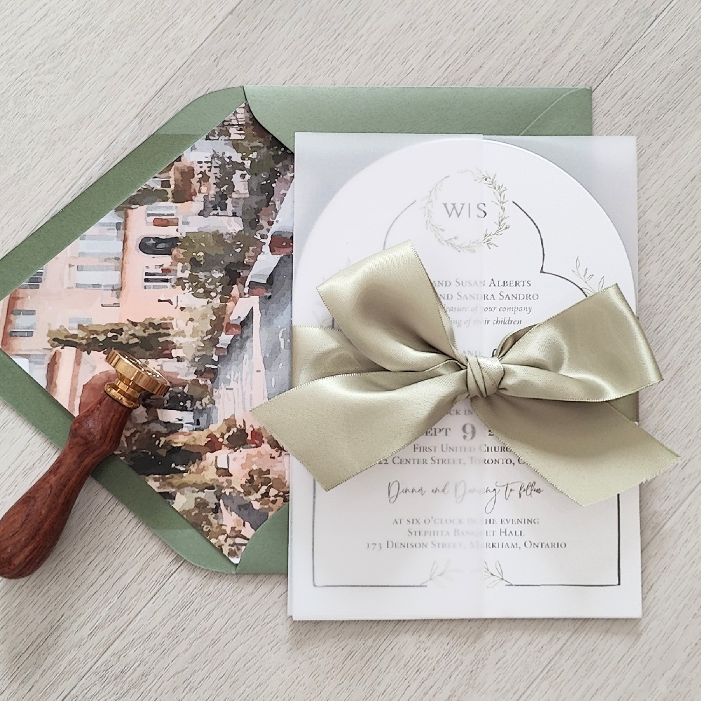 Arch shaped invitation with a full vellum wrap enclosure and light sage ribbon bow.  Mid green envelope with a printed design envelope liner.