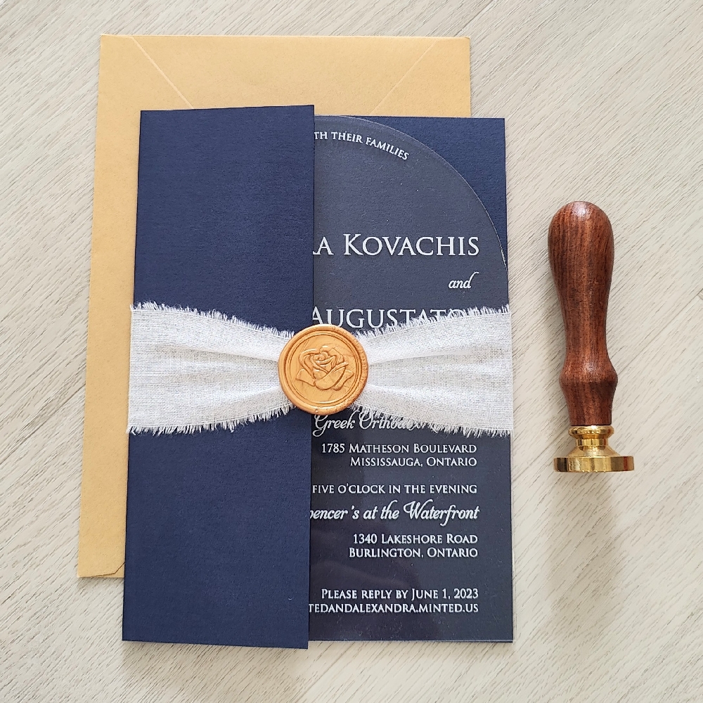 Arch shaped clear acrylic in a gate fold folder with a white ribbon and gold wax seal embellishment.