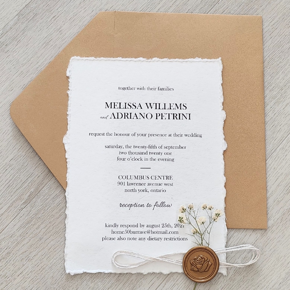 Deckle edge wedding invite with string, wax seal and dried flower embellishment.  Metallic gold envelope.
