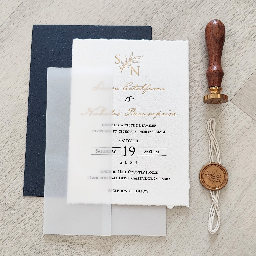 Deckle edge letterpress wedding invitation with Gold Foil stamp printing.  Full vellum wrap enclosure with white string and gold wax seal embellishment.  Navy envelope.