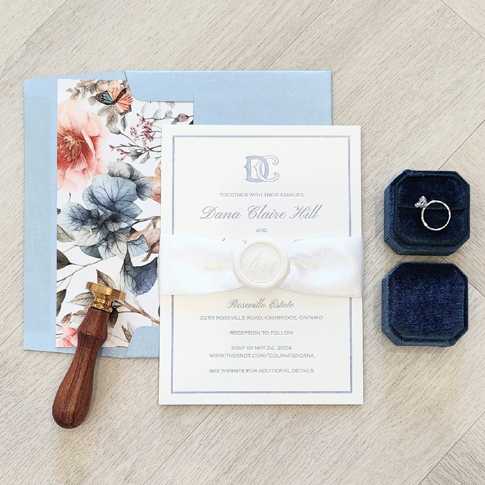Letterpress wedding card with ribbon and wax seal embellishment.  Paired with a blue envelope and printed floral envelope liner.