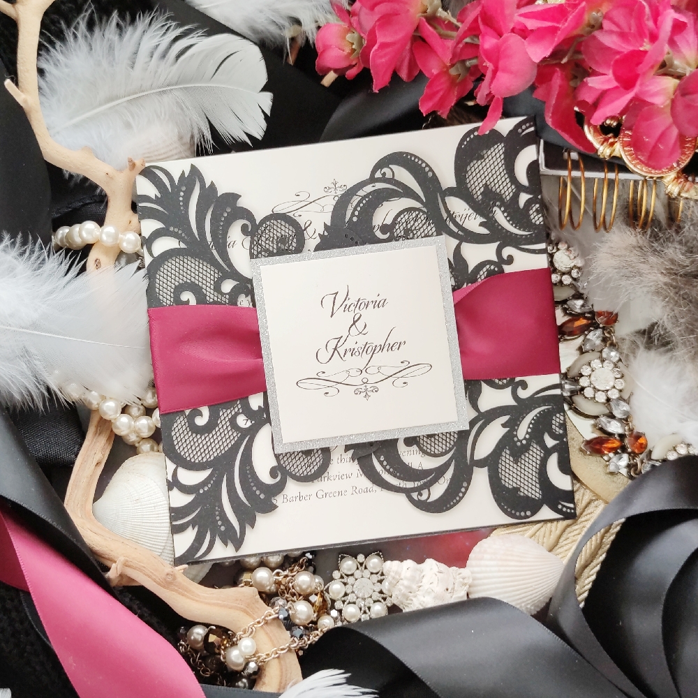 Black lasercut wedding invite with wine ribbon and silver glitter cover tag.