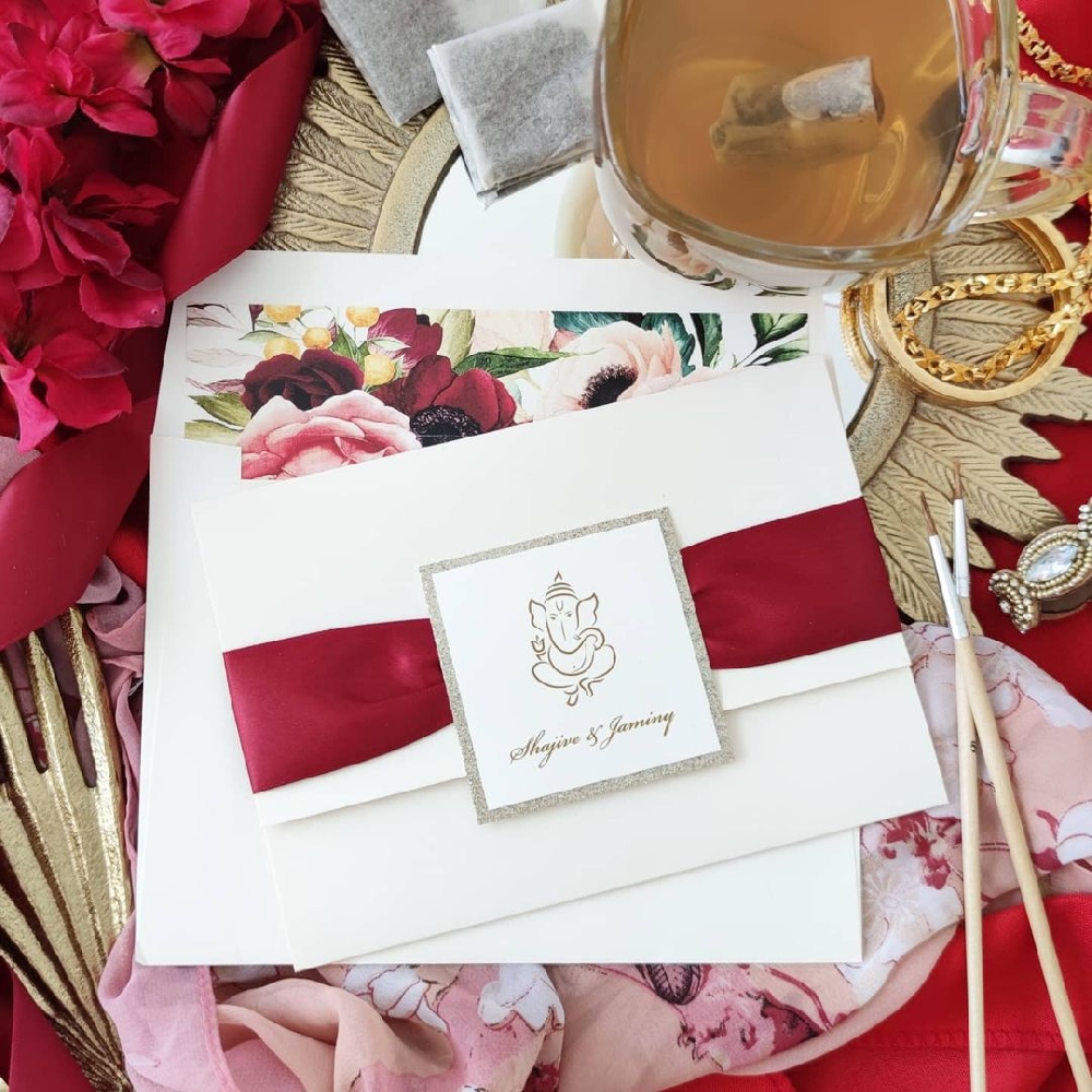 Indian themed wedding invitation with an ivory pockefold and a sherry ribbon.
