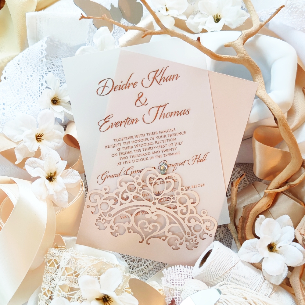 A rose gold foil printed wedding invitation on a vellum stock paper inside a blush lasercut pocket.