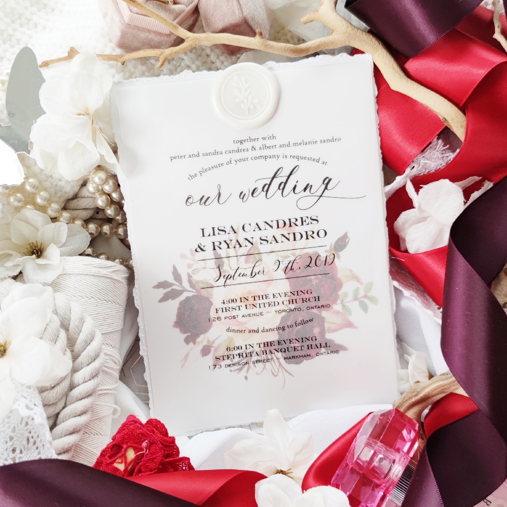 Deckled edge wedding invitation with upgraded wax seal glued at top of card.