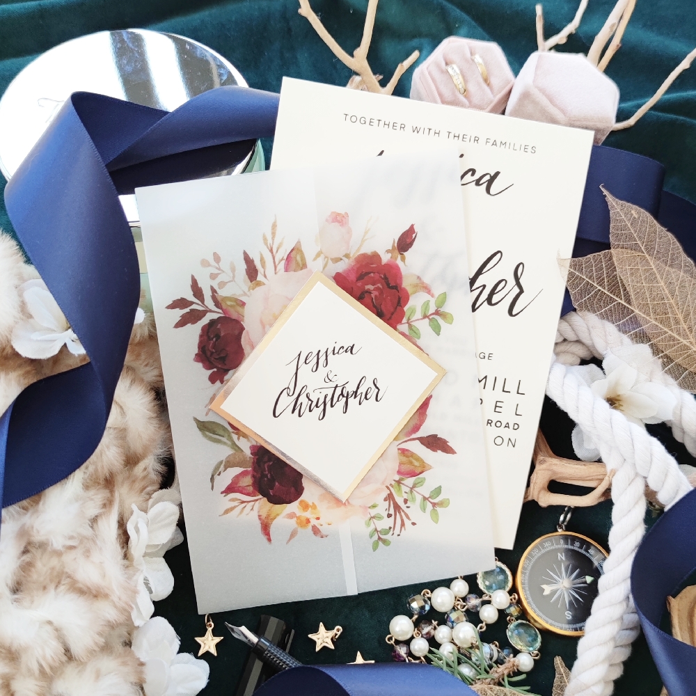 Vellum wrap wedding invitation with floral printing and cover tag.