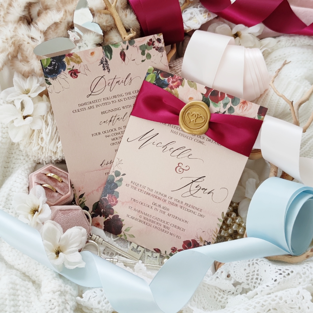 A single card wedding invitation with a burgundy ribbon & gold wax seal.
