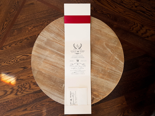 Invitation 1619: White Gold, White Gold, Sherry Ribbon, Brooch/Buckle Q - This is a white gold pearl full flap pocket folder with a sherry ribbon and brooch around the card.