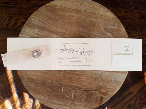 Invitation 1724: White Gold, White Gold, Cream Lace, Brooch/Buckle Q - This is a full flap white gold pearl wedding invitation pocket fold design.  There is a lace trim and brooch on the flap.