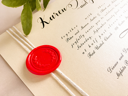 Invitation 2212: Buttermilk Pearl, Red Wax - This is a simple single card invitation that reads landscape.  It uses a string tied around the left side of the invitation with a red wax seal.