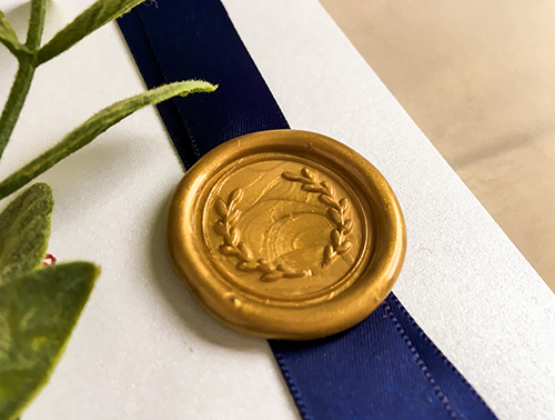 Invitation 2258: This is a bifold wedding invitation with a navy blue ribbon and wax seal on the cover and florals printed on the inside as well as the front of the invitation.