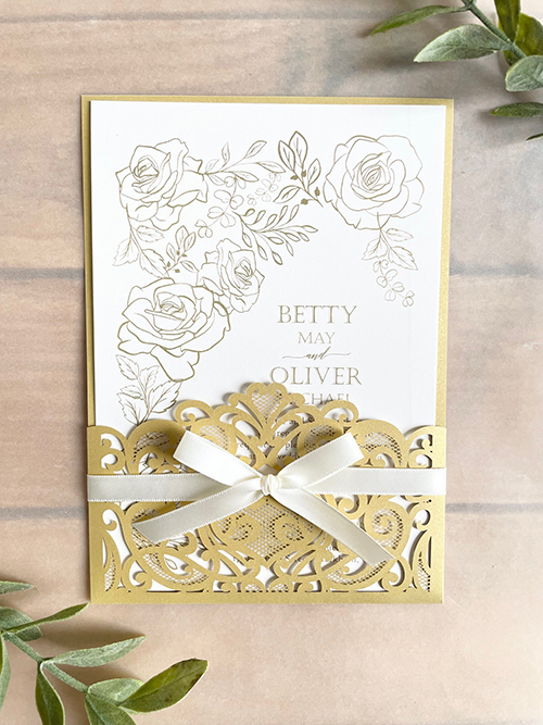Invitation lc159: Antique Ribbon - Metallic gold colored lasercut wedding invitation with a delicate bow.