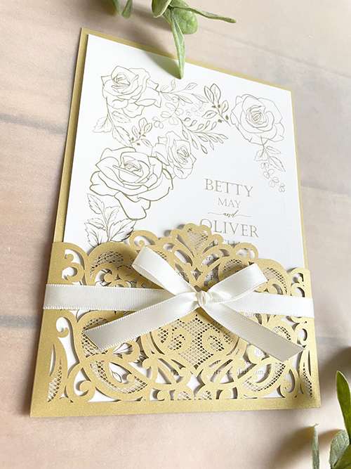 Invitation lc159: Antique Ribbon - Metallic gold colored lasercut wedding invitation with a delicate bow.