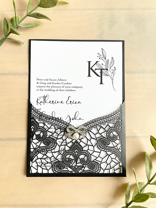 Invitation lc161:  - This is a delicate black lasercut wedding invitation.  The bow brooch on the front adds a soft touch to the black lace design.