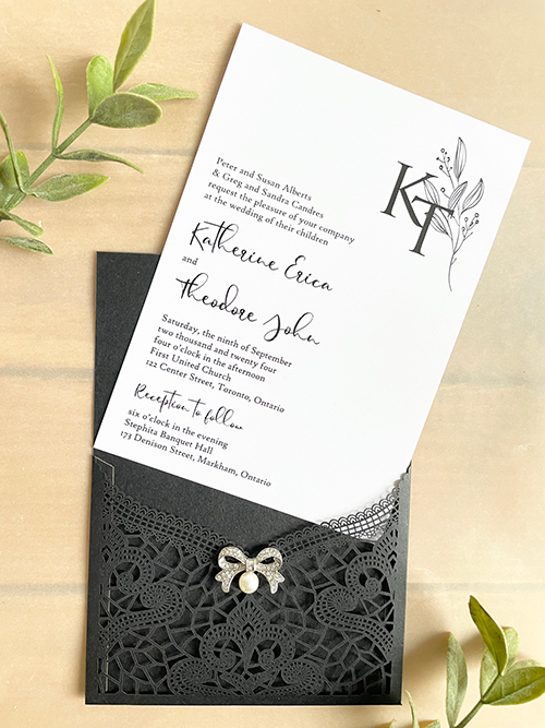 Invitation lc161:  - This is a delicate black lasercut wedding invitation.  The bow brooch on the front adds a soft touch to the black lace design.