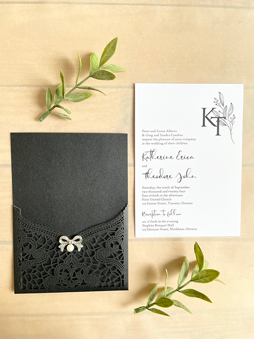 Invitation lc161:  - This is a delicate black lasercut wedding invitation.  The bow brooch on the front adds a soft touch to the black lace design.