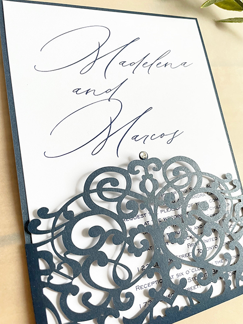 Invitation lc162:  - This is a navy shimmer lasercut wedding invitation with a small rhinestone decorative piece.  The invitation card pulls out of the pocket.