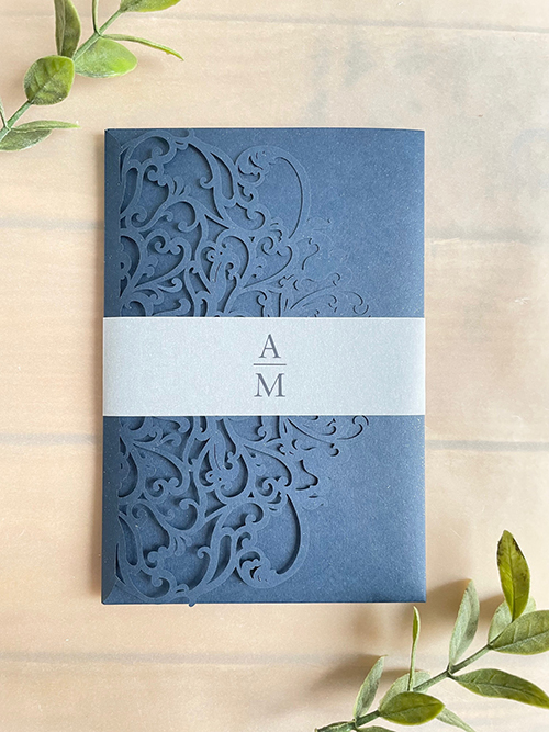 Invitation lc165:  - Navy shimmer lasercut pocketfold with a vellum bellyband around the card.