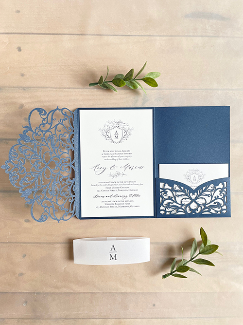Invitation lc165:  - Navy shimmer lasercut pocketfold with a vellum bellyband around the card.