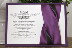 Invitation 1104: Purple Pearl, Cream Smooth, Grape Ribbon, Grape Ribbon, Deep Charcoal Ribbon - Purple pearl layered invite with a grape and charcoal ribbon twist